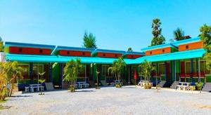 a large building with a blue roof and palm trees at Kwanjai Resort in Ban Mu Dut