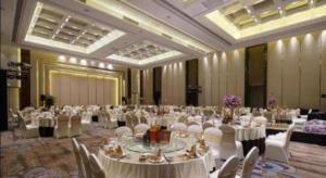 a large banquet hall with white tables and chairs at Beijing Grand Skylight International Hotel in Beijing