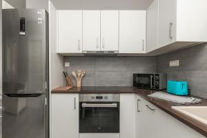 a kitchen with white cabinets and a stainless steel refrigerator at Demargia Villa C - Loft Apartment in Zakynthos Town in Zakynthos Town