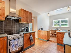 Una cocina grande con gabinetes de madera y una mesa. en 4 Bed in Wigton 95640, en Hayton