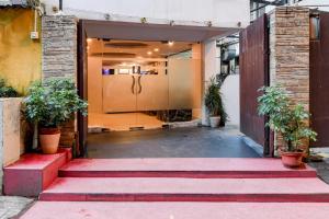an entrance to a building with stairs and plants at Super Townhouse Oak Ballygunge Formerly Hotel Lovelock in Ballygunge