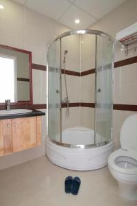 a bathroom with a shower with a toilet and a sink at TVT Hotel in Da Lat