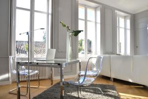 a desk with a laptop and a vase with a plant at The Suites in Blaye