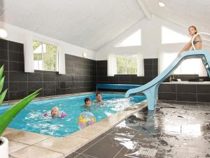 a woman on a slide in a swimming pool at Luxury Retreat with Pool - By Traum Ferienwohnungen in Høruphav