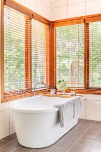 eine Badewanne im Bad mit Fenstern in der Unterkunft Beautiful 2BR Rainforest Retreat Free Wifi in Springbrook