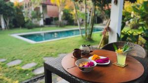 a table with a bowl of food and a drink at Bali Mynah Villas, Balangan Beach in Jimbaran +10 photos