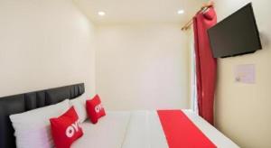 a bedroom with a bed with red and white pillows at 5 Diamond in Bangkok