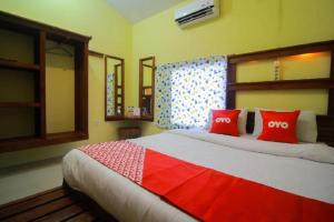a bedroom with a large bed with red pillows at OYO 1596 Taman Homestay Syariah in Dumai