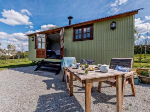 a green tiny house with a picnic table in front of it at 1 Bed in Holsworthy 77361 in Ashwater
