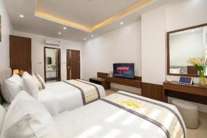 a hotel room with two beds and a television at Chin Luc Hotel in Ðồng Phú +18 photos