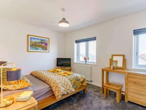 a bedroom with a bed and a dresser and a desk at 2 Bed in St Davids 82312 in St. Davids
