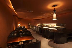 a restaurant with a bar with black leather chairs at Hyatt Regency Tokyo in Tokyo
