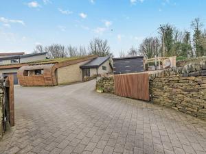 a stone wall next to a building with a fence at 3 Bed in Holmfirth 94342 in Thurlstone