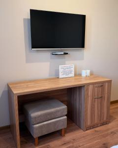 a flat screen tv sitting on top of a wooden desk at Satti in Shymkent