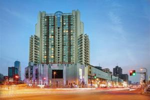 a large tall building with lights in a city at Kingtown Hotel Hongqiao Shanghai in Shanghai