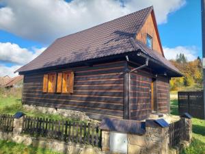 a small wooden house with a brown roof at Chalúpka za Magurou in Matiašovce