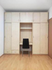 a desk and a chair in a room with cabinets at Ubytovanie v centre s garážovým státím in Piešťany