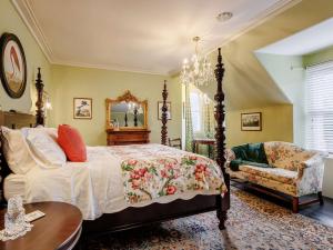 ein Schlafzimmer mit einem Bett, einem Stuhl und einem Spiegel in der Unterkunft 5 Bed in Dunkeld 90844 in Birnam