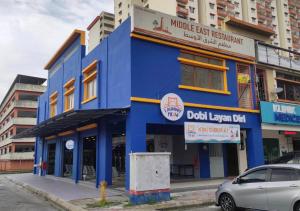 a blue building with a car parked in front of it at Numero X homestay in Kajang