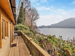 セント・フィルカンズにある1 Bed in Callander 77553の湖の景色を望む家の隣の木製の歩道