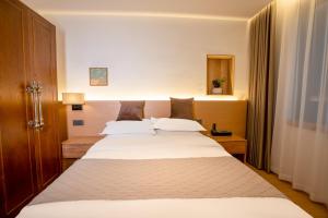 Un dormitorio con una cama grande con sábanas blancas. en Junlan Hotel 张家界郡澜民宿, en Zhangjiajie