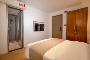 Un dormitorio con una cama y un baño con ducha. en Junlan Hotel 张家界郡澜民宿, en Zhangjiajie