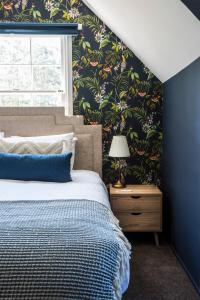 une chambre avec un lit avec un mur bleu dans l'établissement Cartref, Vintage Welsh Charm Meets Modern Comfort, à Mont Dandenong