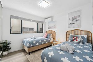 Palm Beach Paradiso في غولد كوست: غرفة نوم بها سريرين ومرآة