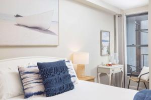 a bedroom with a white bed with a boat on the wall at On the Beach Getaway in One Mile