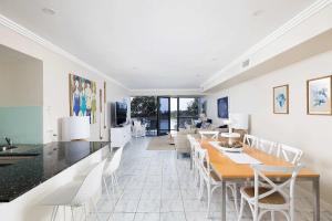 a dining room with a table and white chairs at On the Beach Getaway in One Mile