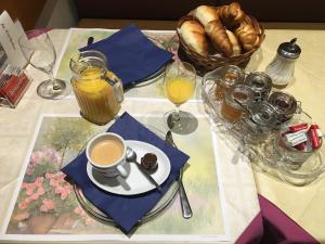 a table topped with a cup of coffee and bread at Au P'tit Bonheur in Cheseaux