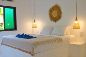 a bedroom with a white bed with a blue towel on it at Lanta Secret House in Ko Lanta