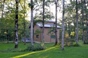 una casa en medio de un bosque de árboles en Résidence le Clos des Chênes en Le Massegros