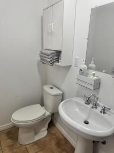 un bagno bianco con un water e un lavandino di Cozy home a Calgary Altre 13 foto