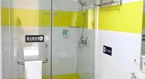 une salle de bain avec une douche avec une porte vitrée dans l'établissement 7 Days Inn Guiyang Gaicha Avenue Guizhou Institute of Technology, à Guiyang