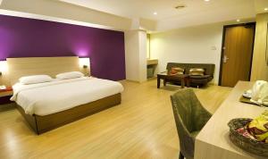 a bedroom with a bed and a purple wall at Borneo Hotel in Pontianak +67 photos