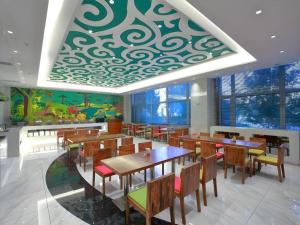 a dining room with tables and chairs and a mural at Harbin Ju Jian Hotel in Harbin
