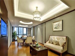 a living room with a table and a dining room at Howard Johnson Zunyue Hotel Chengdu in Chengdu