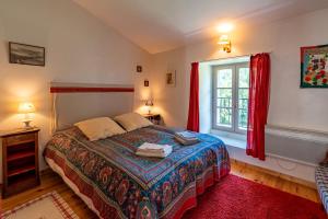 a bedroom with a bed and a window with red curtains at Gîte Les Ailliers in La Chaudière