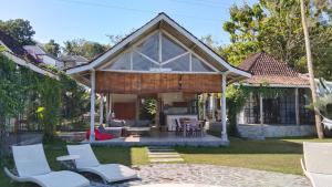 a house with a conservatory with white chairs at Sun Moon Star Villas with One Bedroom Private in Jarakan