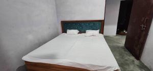 a bedroom with a large bed with white sheets at HOTEL O BLUE ROSE in Sītāpur