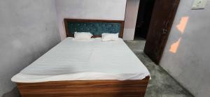 a bed with white sheets and pillows in a room at HOTEL O BLUE ROSE in Sītāpur