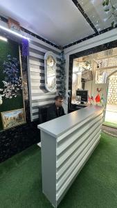 a man is sitting at a counter in a store at Hotel Ravshanbek in Samarkand