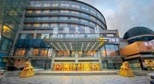 a large building with people standing outside of it at Qingdao Blue Horizon Hotel Laoshan in Qingdao