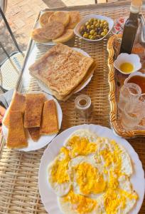 una mesa con platos de huevos, pan y tostadas en Le calme de la campagne, le souffle de l'océan, en Khemis du Sahel 11 fotos más