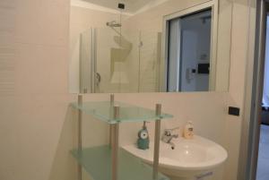 ミラノにあるStudio Errepi Carrobbioのバスルーム(ガラスの洗面台、鏡付)