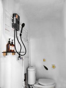 Un baño con inodoro y un teléfono en la pared. en Friends Retreat Phuket, en Ban Bo Han