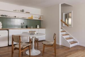 a kitchen with a table and chairs and a staircase at The Local Studio - Luxury over 2 levels in Byron Bay