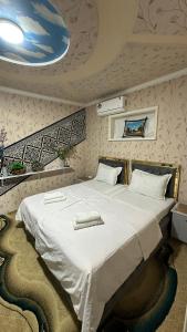 a bedroom with a large white bed in a room at Hotel Ravshanbek in Samarkand