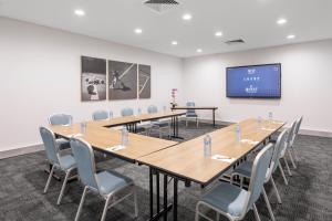a conference room with a long table and chairs at Quest at Sydney Olympic Park in Sydney